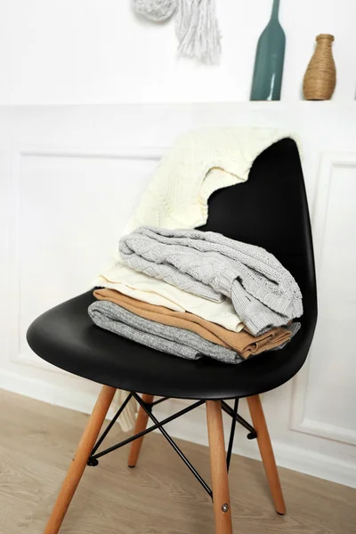 Pilha de roupas na cadeira preta — Fotografia de Stock