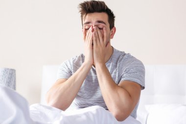 Uykulu genç adam yatakta 