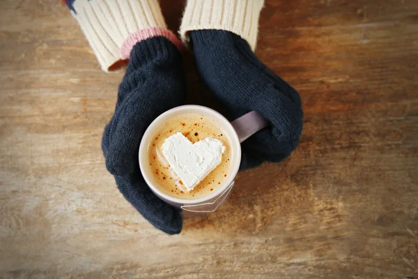Hands in mittens holding cup — Stock Photo, Image