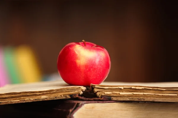 Libros y manzana sobre la mesa — Foto de Stock