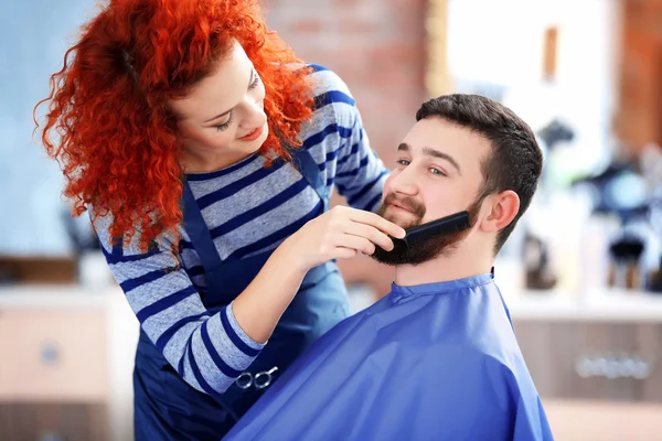 Перукар розчісує чоловіка борода — стокове фото
