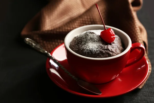 Bolo de chocolate em uma caneca vermelha com uma cereja — Fotografia de Stock