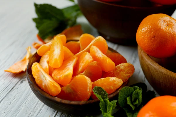 Stukjes mandarind op houten tafel — Stockfoto