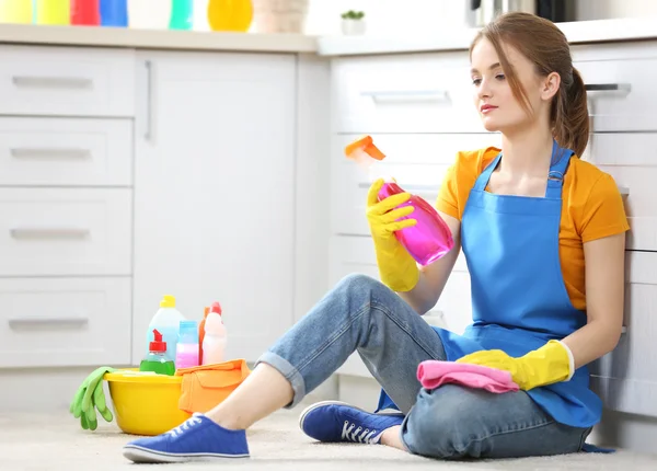 Mujer joven sentada con fluidos de limpieza — Foto de Stock