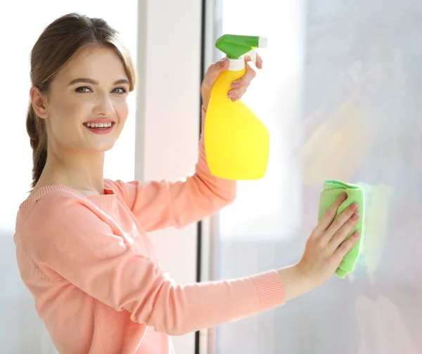 Junge Frau beim Fensterputzen — Stockfoto