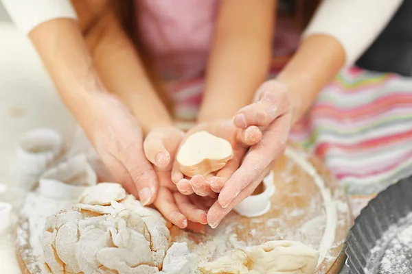 Mother and daughter cutting cookie shapes