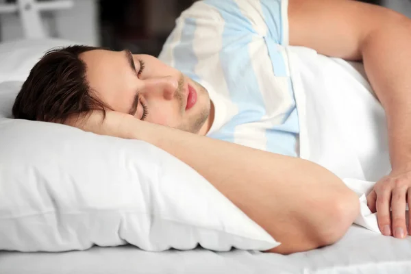 Ung man sover i sängen — Stockfoto