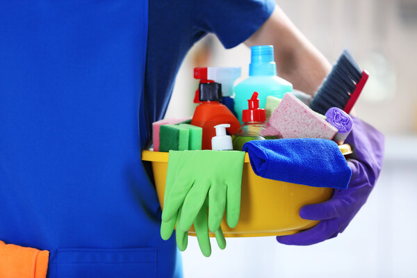 Человек держит раковину кисточками и перчатками
