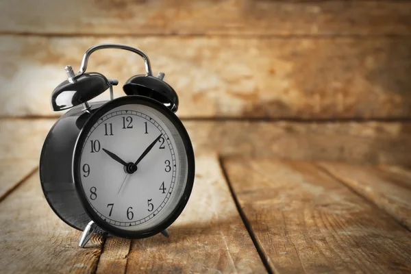 Alarm clock on wooden table — Stock Photo, Image