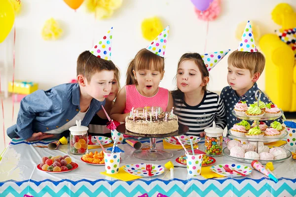 Boy blowing on cake with candles — Stock Photo © pressmaster #47778499