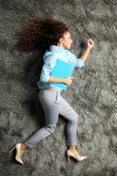 床に横になっているフォルダーを持つ女性 — ストック写真