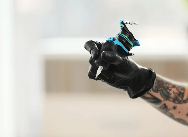 Man's hand holding tattoo machine — Stock Photo, Image