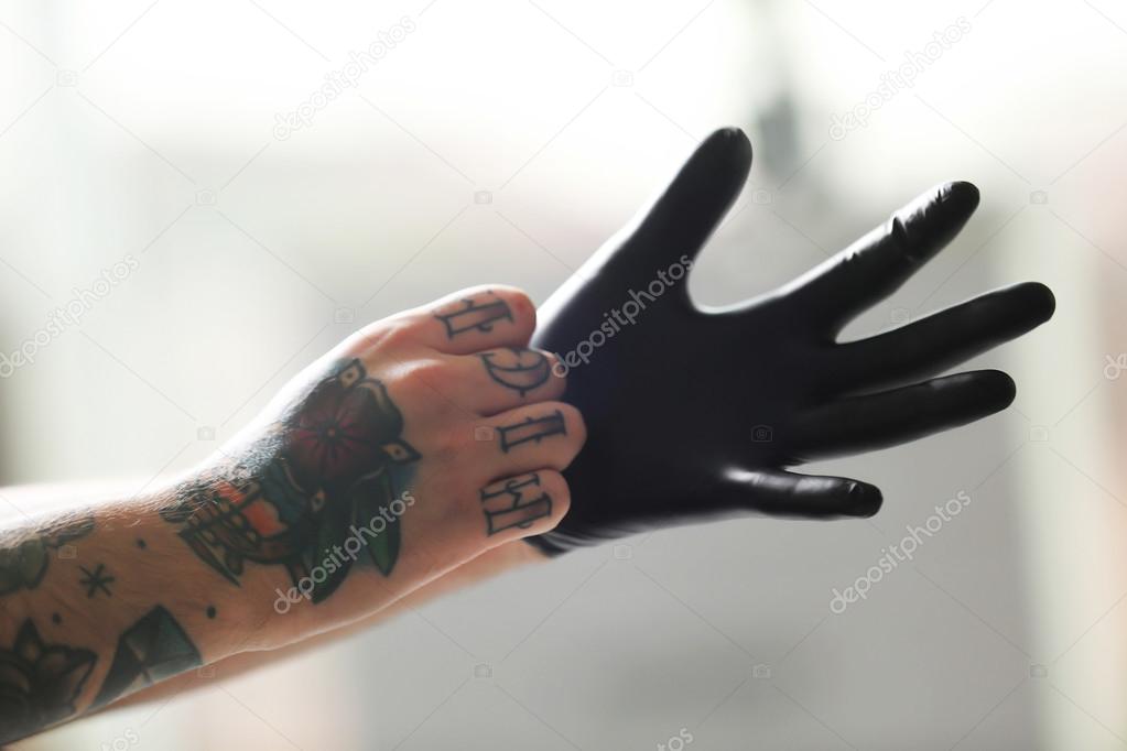 Man with tattoo wearing gloves Stock Photo by ©belchonock 108181708