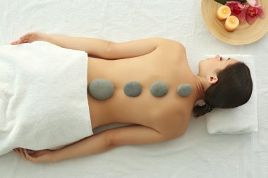 Spa kavramı. Kadın sırtında çakıl taşları ile rahatlatıcı