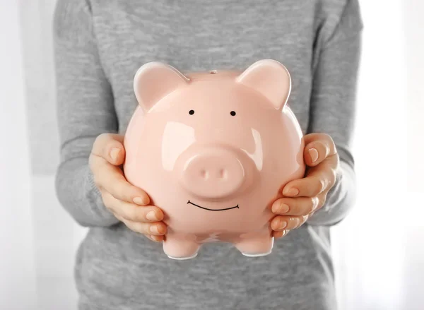 Piggy bank in handen — Stockfoto