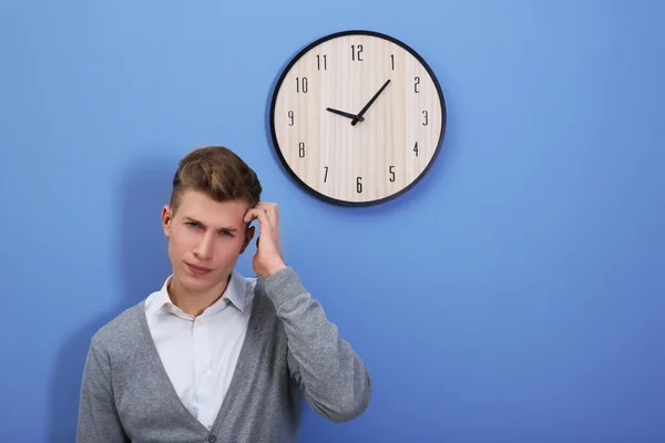 Homem e relógio na parede azul — Fotografia de Stock