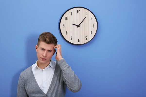 Hombre y reloj en la pared azul — Foto de Stock