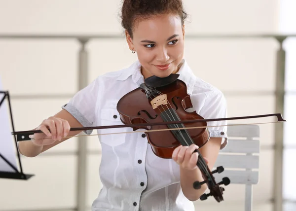 Молодая девушка играет на скрипке — стоковое фото