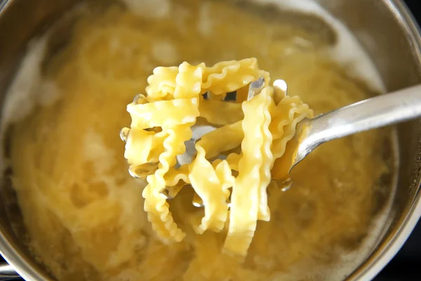 Nudeln im Löffel über Pfanne — Stockfoto