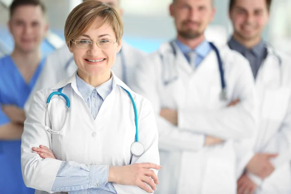 Uśmiechnięty Lekarz Pracownikami Medycznymi Stojącymi Szpitalu — Zdjęcie stockowe