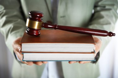 Tahta tokmak ile kitap tutan adam  