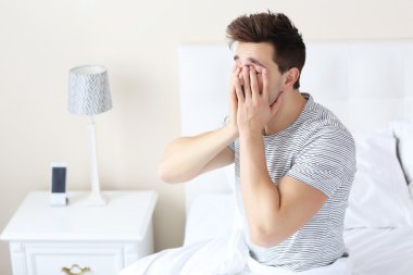 Uykulu genç adam yatakta 