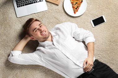 Dizüstü bilgisayar ve pizza genç işadamı