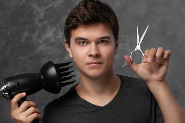 Saç kurutma makinesi ve makas ile yakışıklı adam