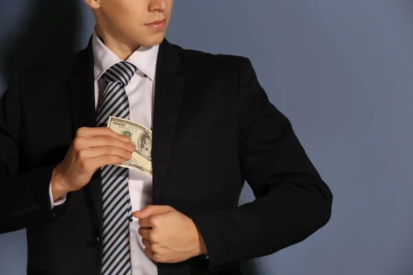 Hombre atractivo escondiendo billetes de dólar — Foto de Stock