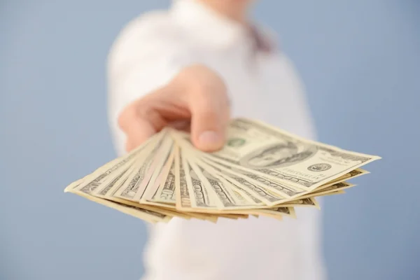 Hombre sosteniendo un ventilador de billetes de dólar — Foto de Stock