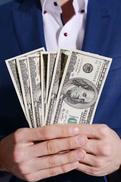 Man holding a fan of dollar banknotes — Stock Photo, Image