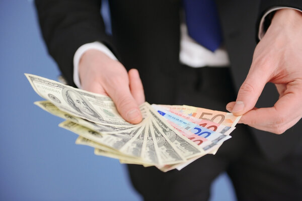 Man holding a fan of dollar banknotes