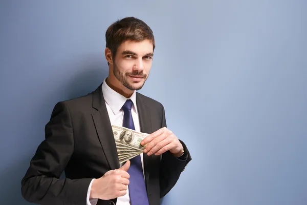 Man in a suit holding dollar banknotes — Stock Photo, Image