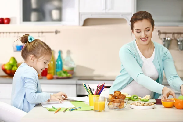 Pregnant Woman Making Dinner While Her Daughter Painting — Stock Photo, Image