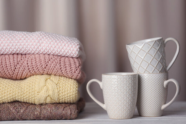 Stack of knitted clothes and cups