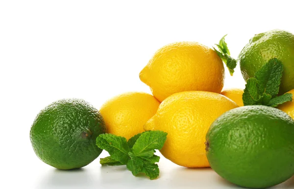 Limoni e lime con rametti di menta isolati — Foto Stock