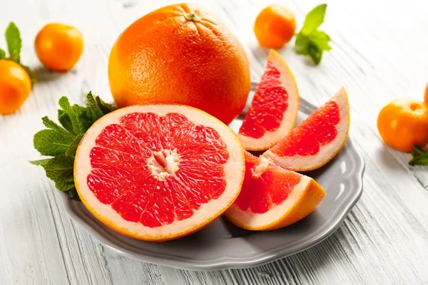 Stukken van grapefruit op houten achtergrond — Stockfoto