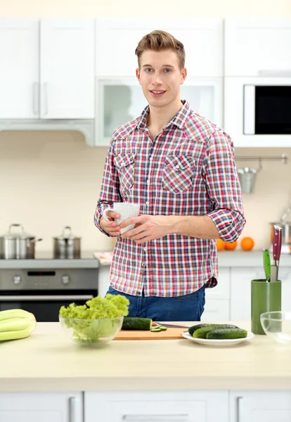 Uomo con tazza in cucina luminosa — Foto Stock