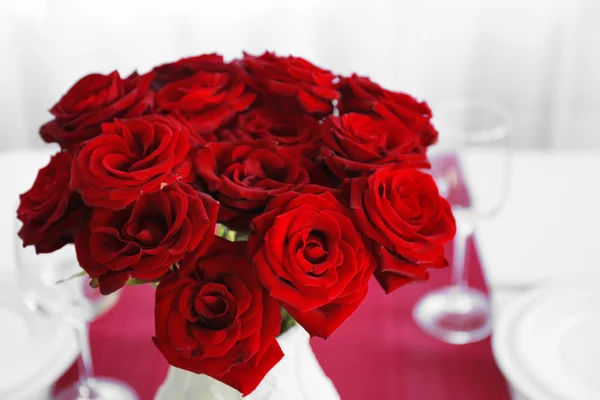 Vase avec des roses rouges sur une table de vacances — Photo