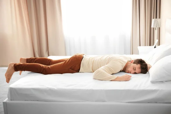 Ubrany człowiek śpi na łóżku — Zdjęcie stockowe