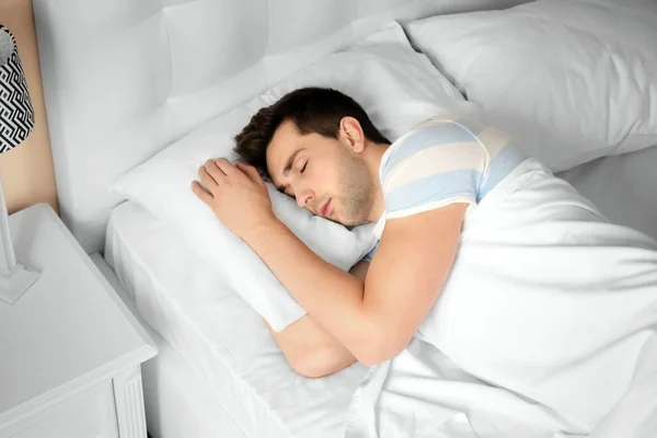 Junger Mann schläft im Bett — Stockfoto