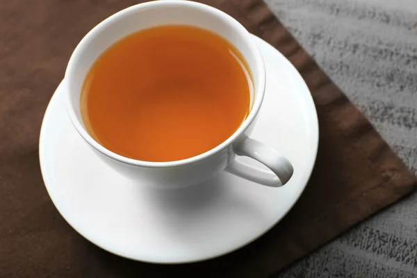 Tazza di tè sul tovagliolo marrone — Foto Stock