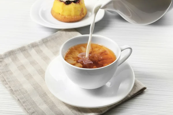 Milk poured into cup of tea — Stock Photo, Image