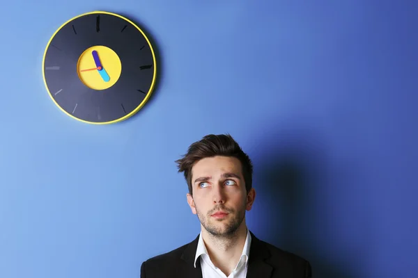 Homme debout à côté d'une grande horloge — Photo