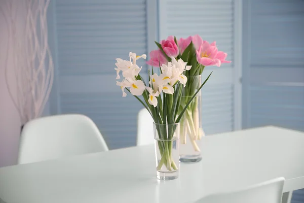 Тюльпаны и ирисы на обеденном столе — стоковое фото