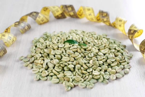 Groene koffiebonen met het meetlint — Stockfoto