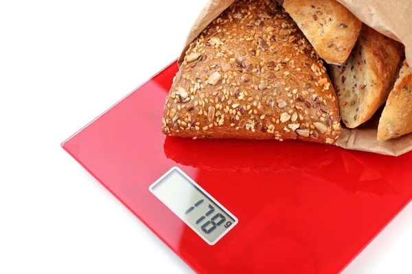 Tasty bread on digital kitchen scales — Stock Photo, Image