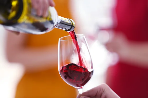 Echar vino tinto de la botella en el vaso — Foto de Stock