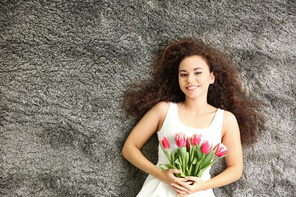 Mulher com tulipas deitadas no chão — Fotografia de Stock