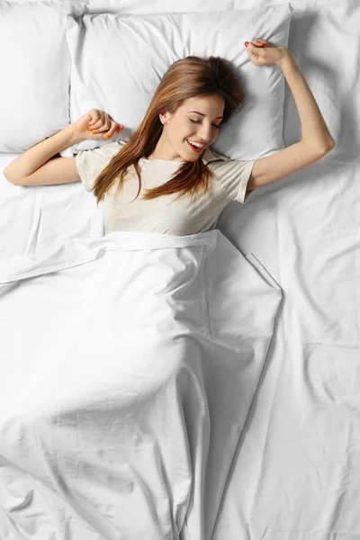 ベッドに寝そべってる若い女性 — ストック写真